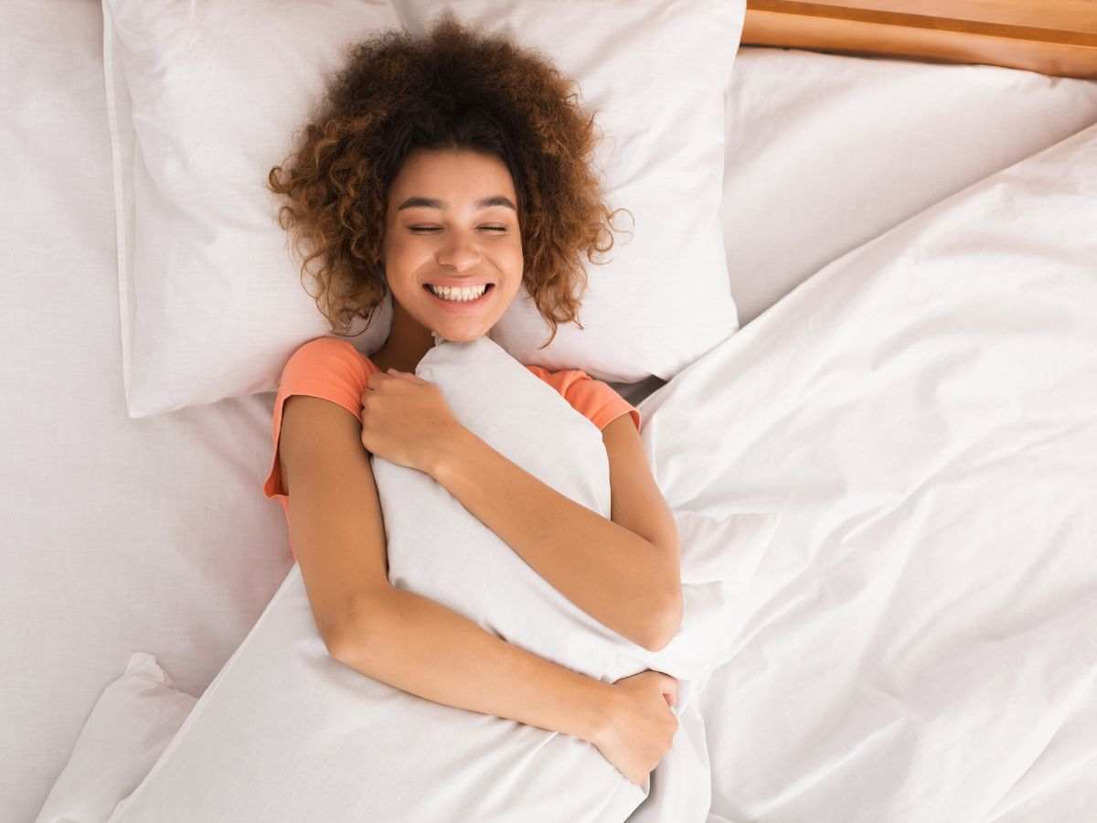 donna sorridente abbraccia cuscino