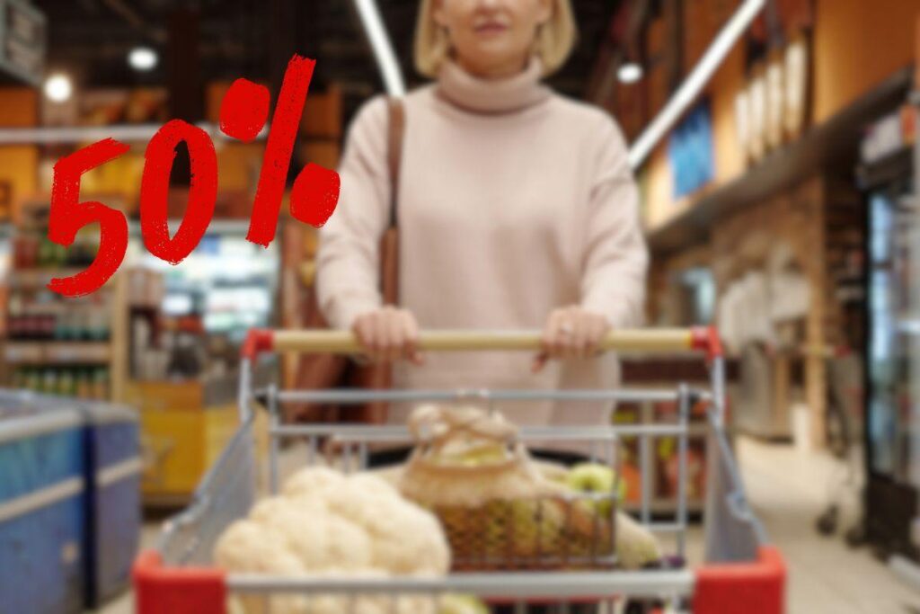 donna con carrello pieno di spesa e 50% di sconto
