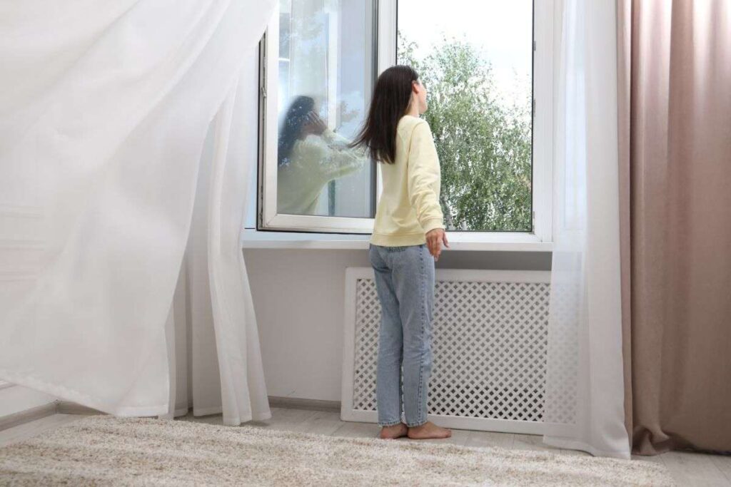 donna che si trova vicino ad una finestra