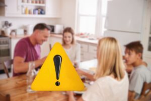 famiglia che mangia e segnale di pericolo