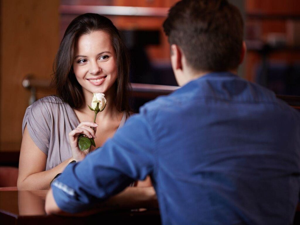 donna con rosa in mano e uomo di spalle