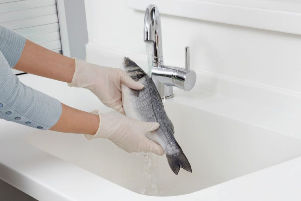 donna lava pesce nel lavandino
