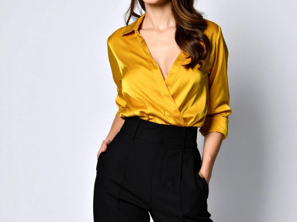ragazza con camicetta oro e pantalone nero a vita alta