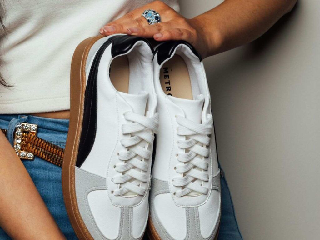 donna tiene in mano un paio di sneakers