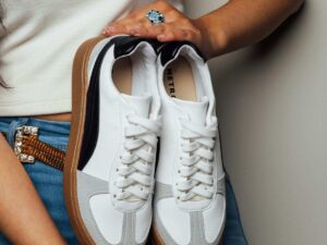 donna tiene in mano un paio di sneakers